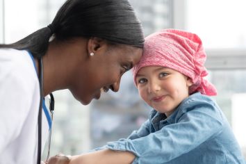 Nurse touching forehead to pediatric patient