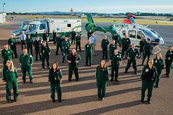 The University of Vermont Health Network Regional Transfer Center staff standing outside in front of helicopter and regional transport ambulance